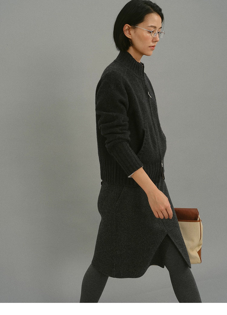 Side walking view of woman wearing dark charcoal wool zip-up cardigan and wool skirt