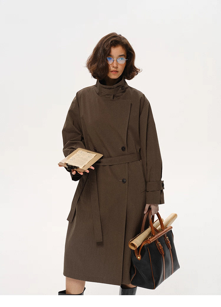 Coffee brown stand-collar city trench coat shown in full front view with bag and notebook.