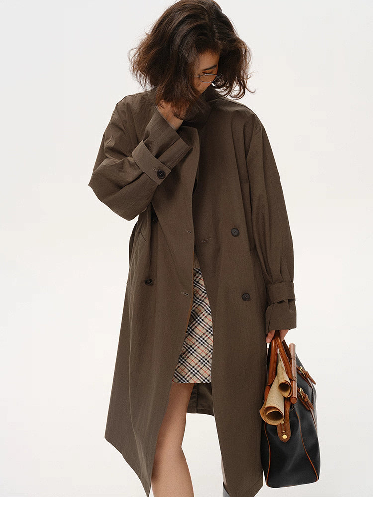 Coffee brown trench worn open, showing motion and layered skirt underneath.