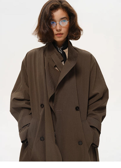 Half-body view of coffee brown trench coat with hands in pockets and relaxed drape.