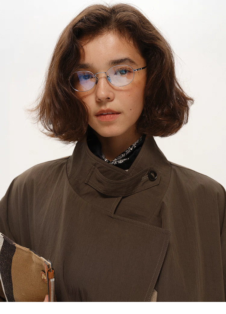 Close-up of stand collar, button and wrapped placket in coffee brown cotton-nylon trench.