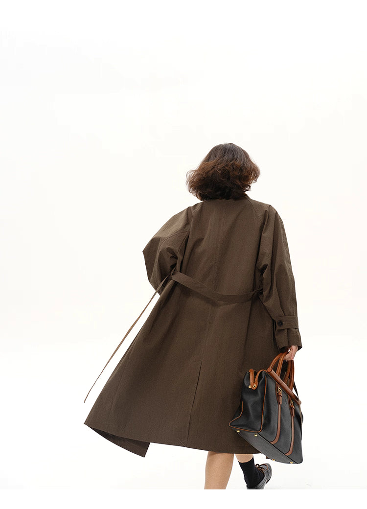 Back view of coffee brown city trench with belt trailing, showing long swing silhouette.