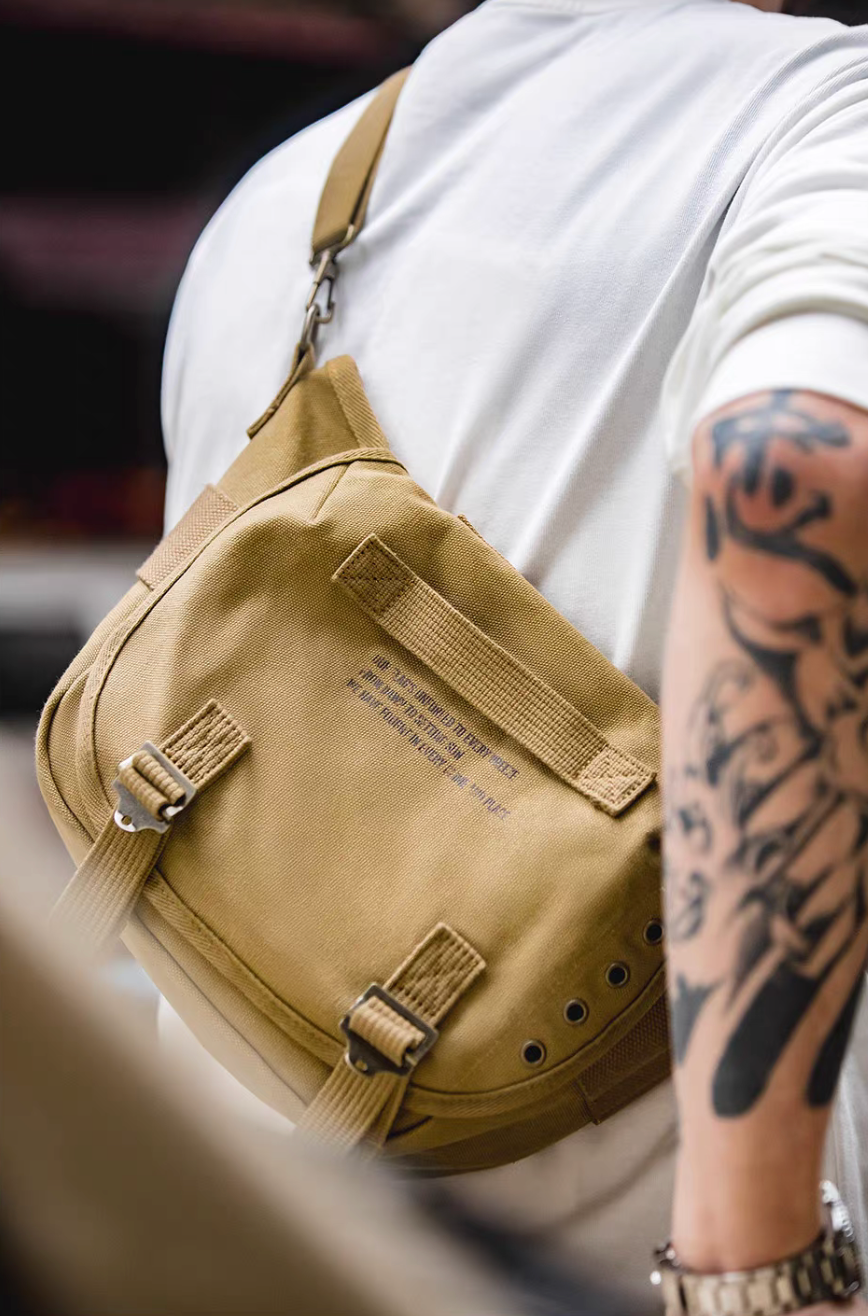 Man wearing khaki Classic M1961 canvas motorcycle bag crossbody style showing compact size and rugged outdoor look