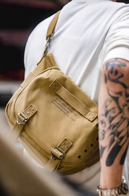 Man wearing khaki Classic M1961 canvas motorcycle bag crossbody style showing compact size and rugged outdoor look