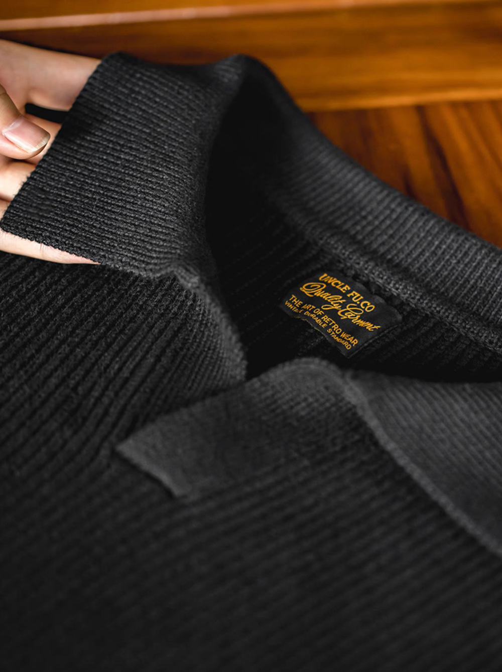 Classic Ribbed Knit Polo Sweater black close-up of collar and ribbed knit fabric texture with brand label detail