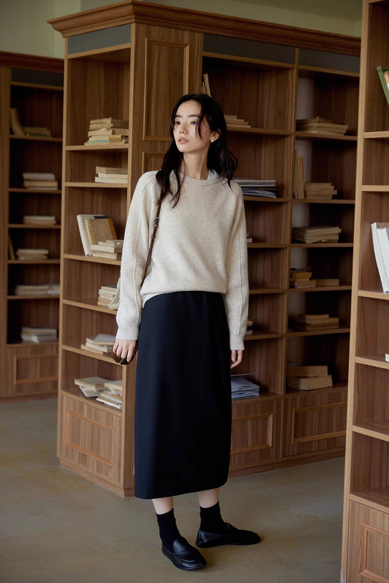 Model wearing The Classic Sculpted Midi Skirt in black front full body view paired with knit sweater showcasing high waist and streamlined silhouette