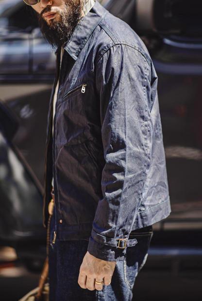 Side view of Dark Blue Classic Trail Waxed Jacket on model highlighting sleeve buckle, chest pocket and waxed texture