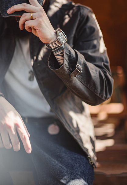 Close-up of Pewter Gray Classic Trail Waxed Jacket showing sleeve shape, adjustable cuff strap and waxed fabric texture