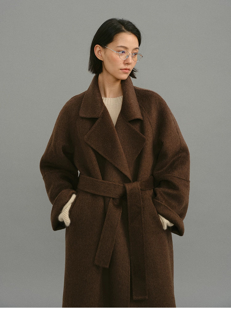 Dark coffee camel-blend coat shown belted from the front with wide lapels.