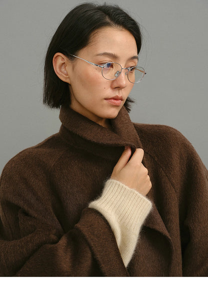 Close-up of plush camel-wool-silk texture and collar with cream knit cuff detail.