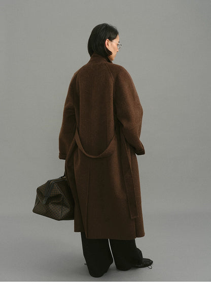 Full back view of oversized dark coffee wrap coat showing belt loop and hemline.