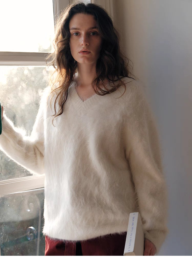 Cloud white wool sweater front view near window showcasing clean minimalist style and soft knit texture