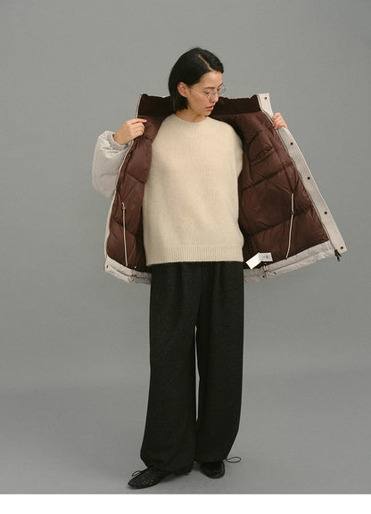 Full-body view of model opening the light greige coat to show the dark brown quilted lining.