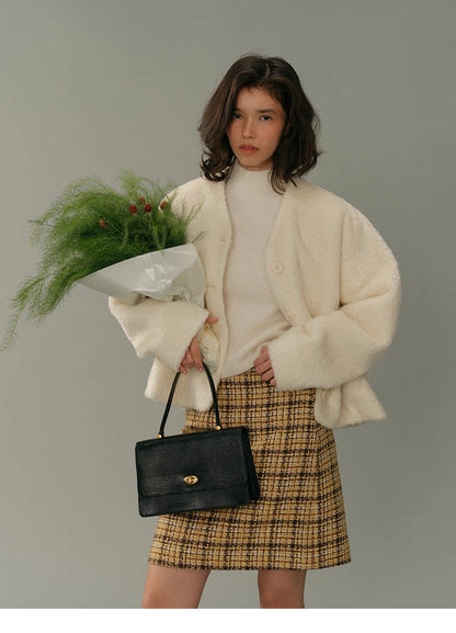 Cream HaloFuzz alpaca turtleneck tee layered under an ivory fuzzy coat, styled with a yellow tweed mini skirt, bouquet in hand.