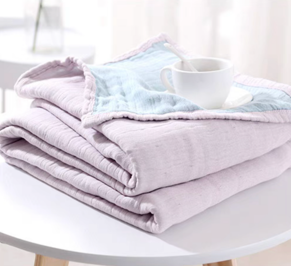 CloudSoft Four-Layer Gauze Cotton Blanket in Purple Blue folded on table with soft layered gauze texture and coffee cup styling