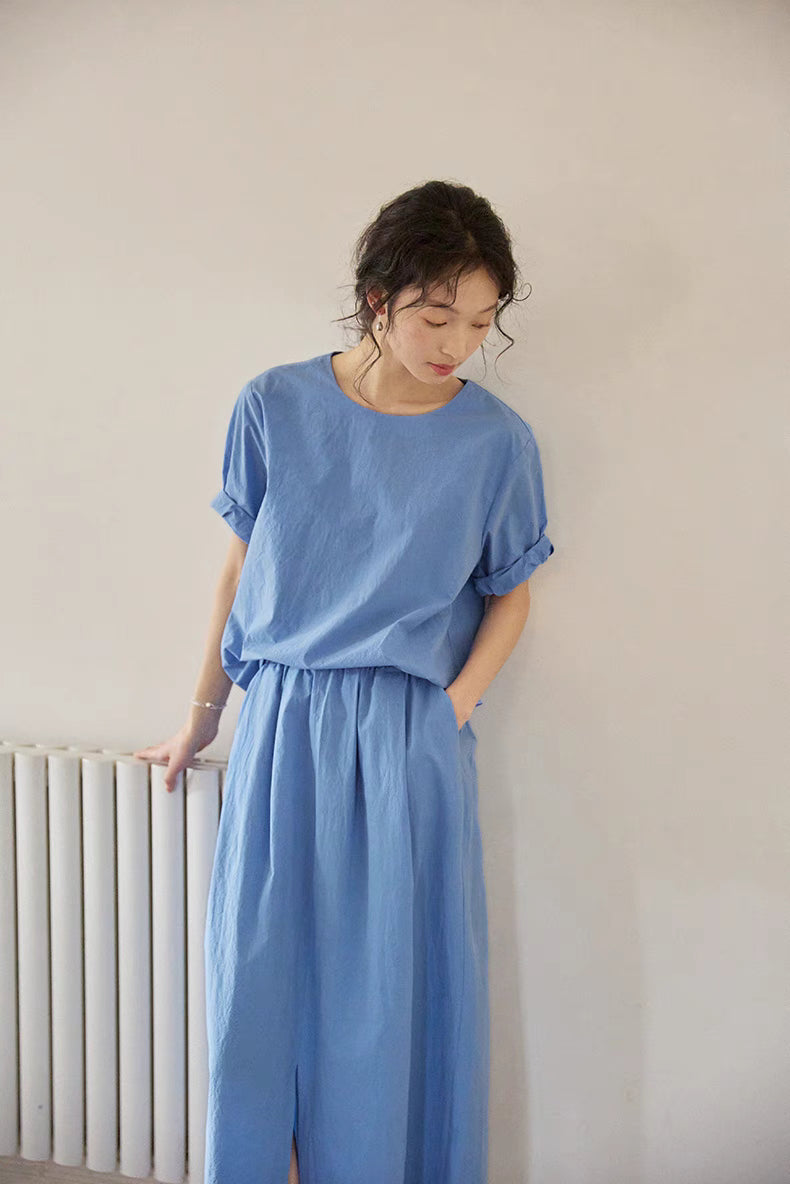 Model wearing Coastal Breeze Cotton Top &amp; Skirt Set in blue front view featuring relaxed short sleeve top and elastic waist midi skirt with front slit