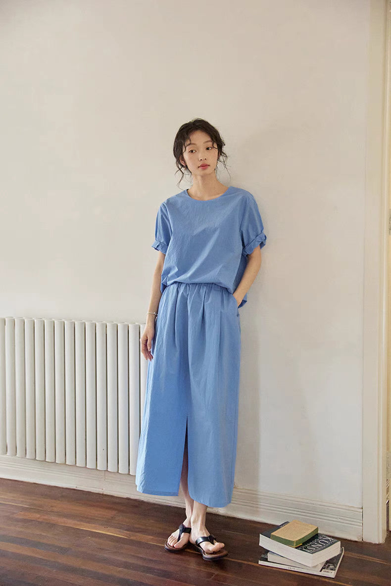 Full body view of Coastal Breeze Cotton Top &amp; Skirt Set in blue showing lightweight cotton fabric, relaxed fit and front slit skirt styled casually indoors