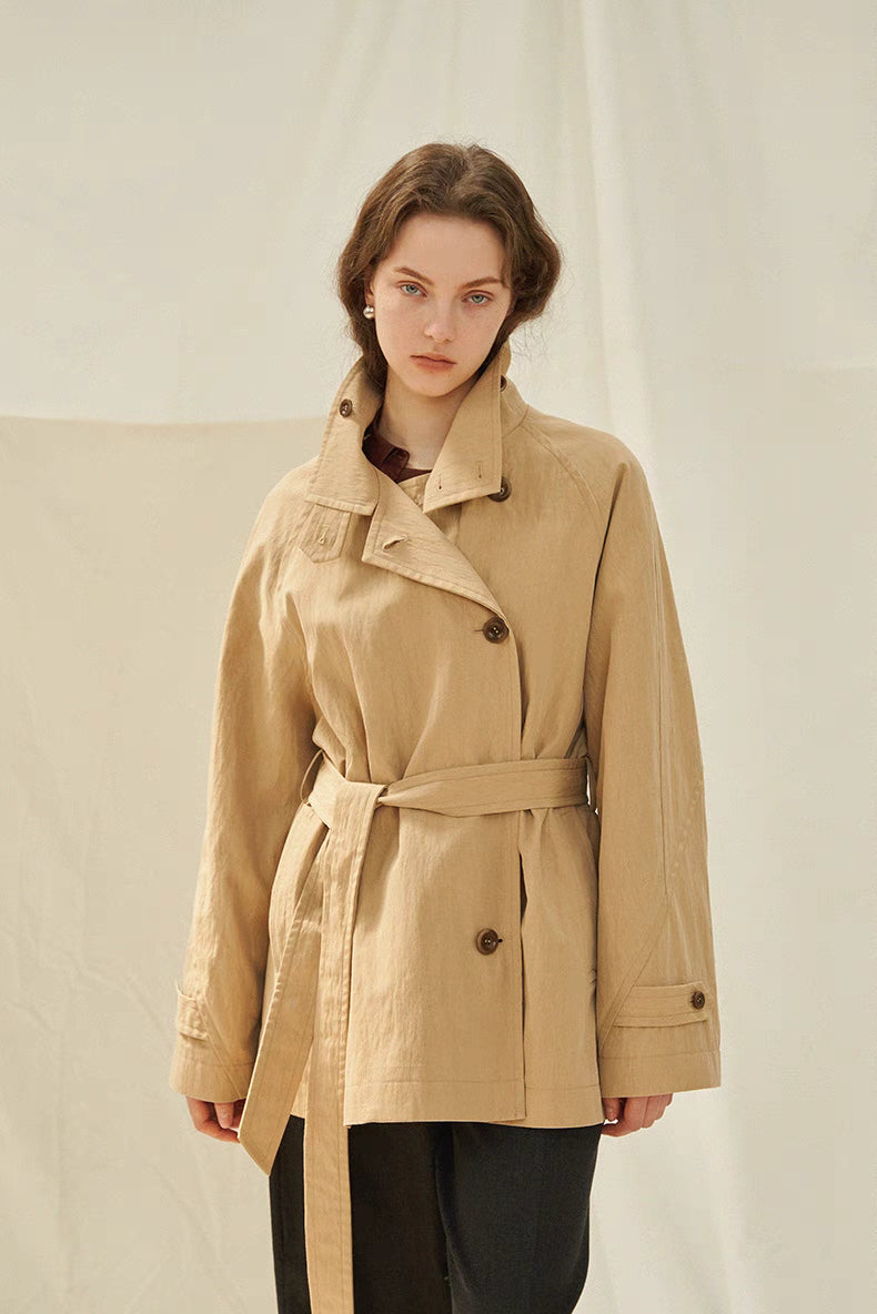 Light brown coastal journey trench coat front view with belt tied, structured collar and relaxed fit