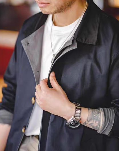 Close-up of navy blue trench coat with contrast collar and button details – modern minimal design.
