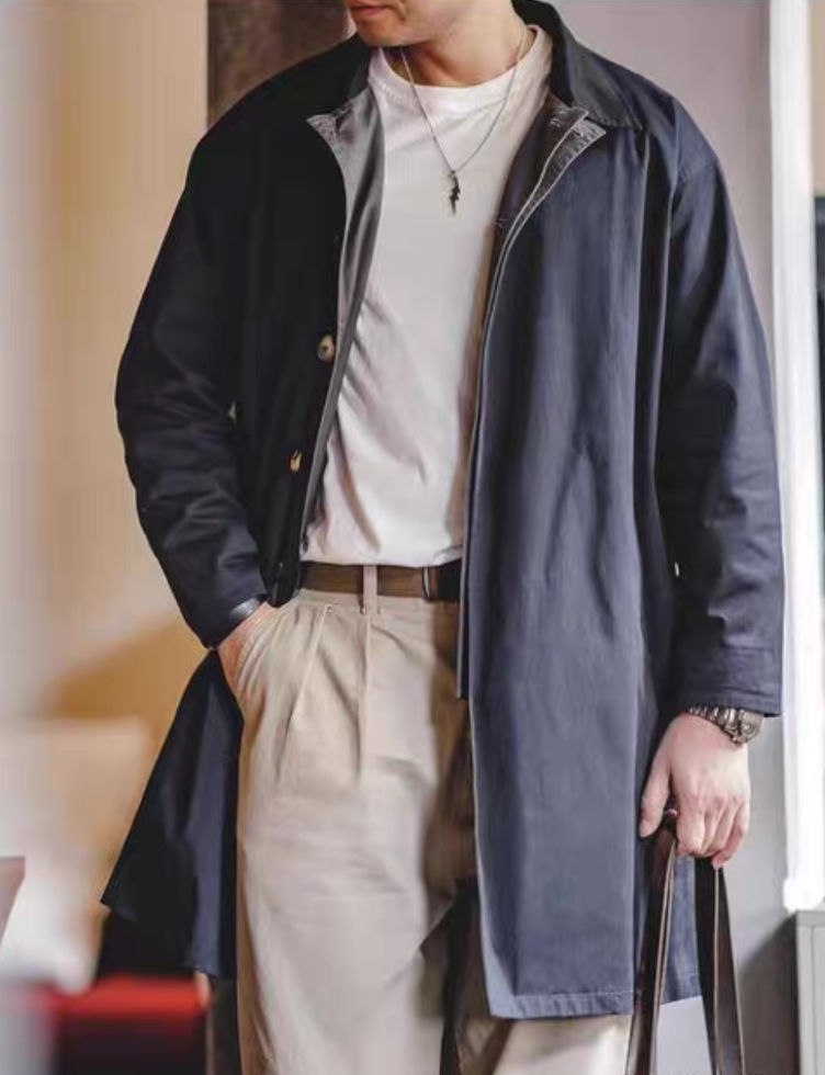 Men’s navy blue contrast-collar trench coat styled with white tee and beige trousers – smart casual look.