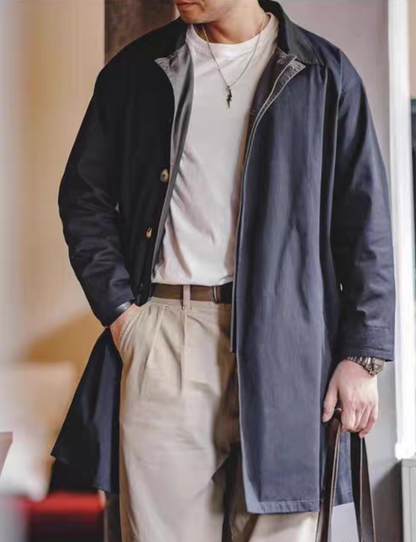 Men’s navy blue contrast-collar trench coat styled with white tee and beige trousers – smart casual look.
