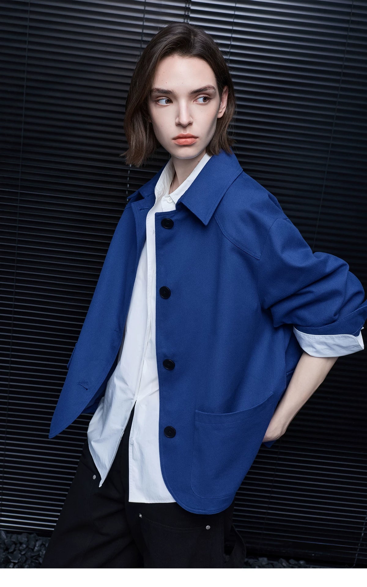 Three-quarter view of a Cobalt Blue cotton chore jacket with point collar and rounded front hem