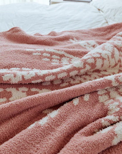 Close-up of pink coconut throw blanket highlighting plush fuzzy texture and white palm tree details