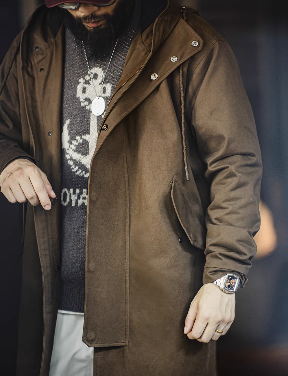 Close-up of Coffee Brown Cotton Windbreaker Coat in army green worn open showing layered outfit and front button details