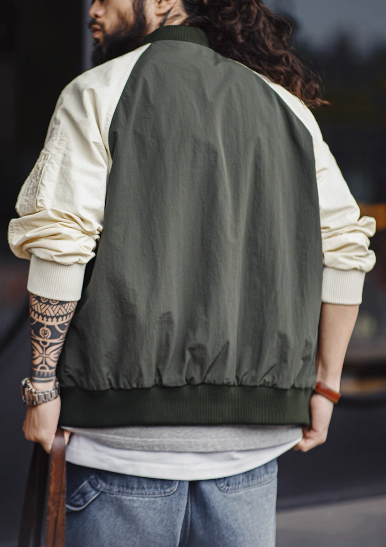 Back view of color-blocked MA-1 bomber showing green body and cream sleeves