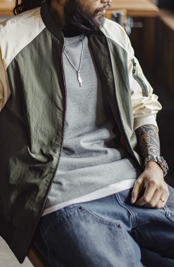 Model sitting in two-tone MA-1 bomber showing relaxed fit and texture