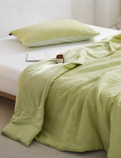 Green Colorful cotton comforter and sham set draped across bed with soft jacquard wave texture