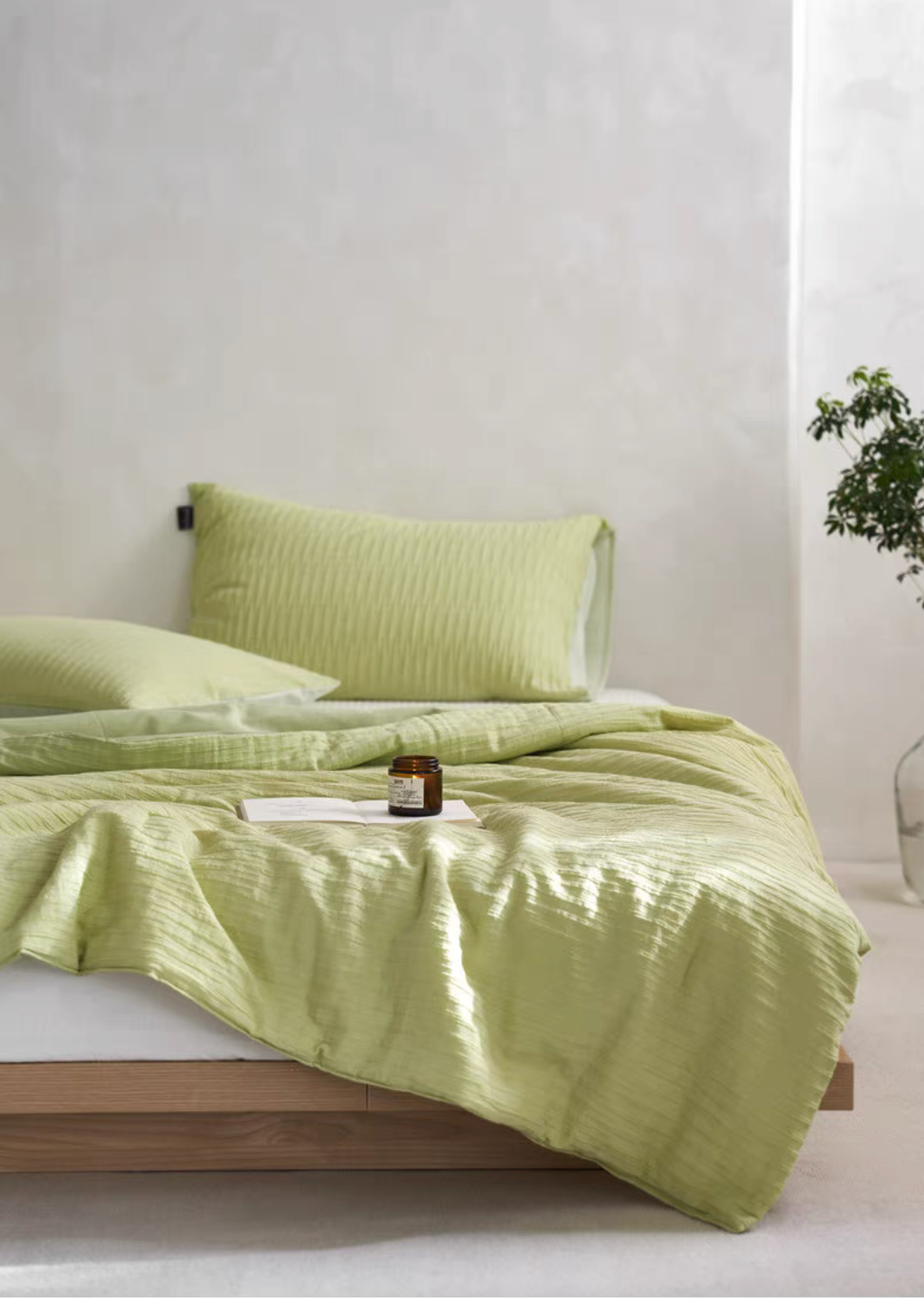Green Colorful cotton comforter and sham set displayed on bed with pillow sham and minimal bedroom background