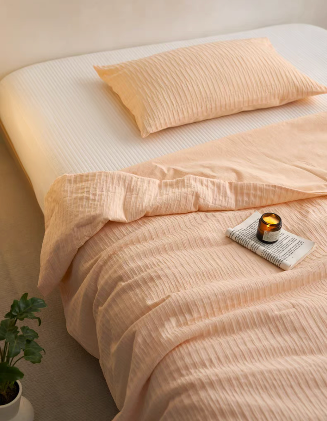 Orange Colorful cotton comforter and sham set close-up with candle, pillow sham, and washed cotton texture