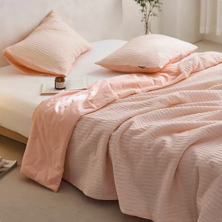 Pink Colorful cotton comforter and sham set with jacquard wave texture draped across a bed in a minimalist bedroom