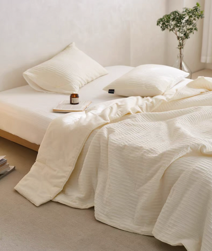 White Colorful cotton comforter and sham set draped across bed with soft jacquard wave texture and matching pillow shams