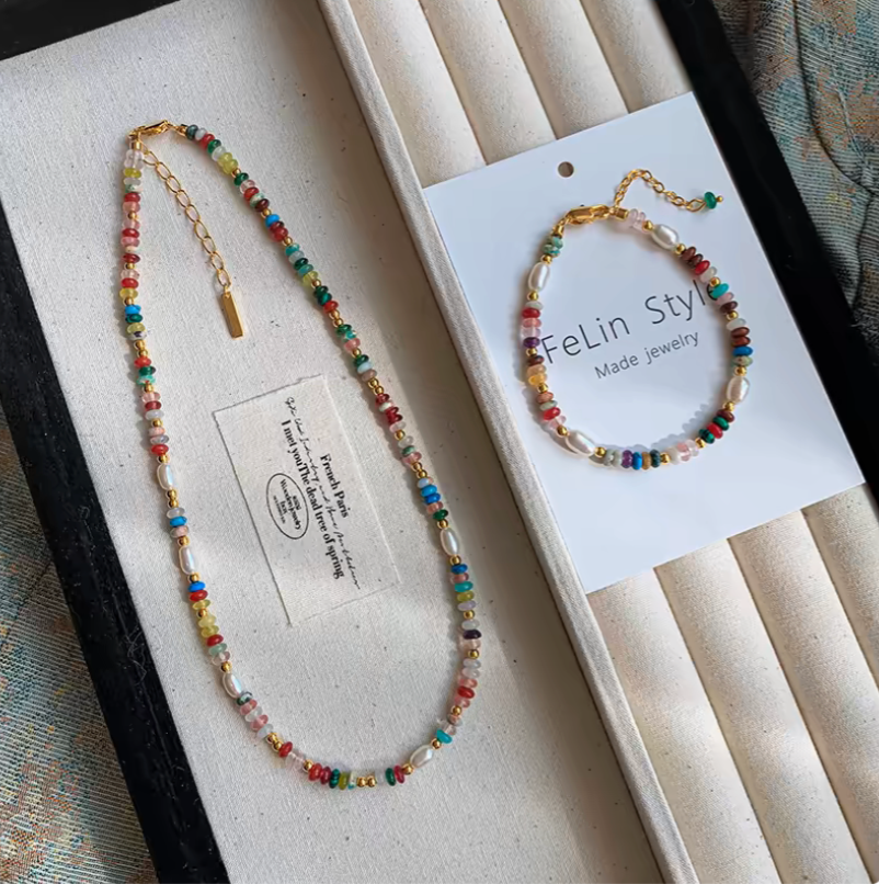 Colorful gemstone and pearl jewelry set featuring multicolor beaded necklace and matching bracelet with freshwater pearls and gold accents displayed on tray