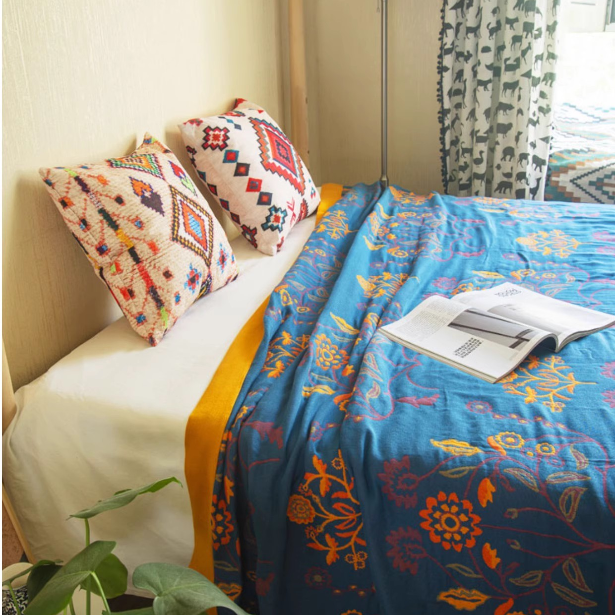 Colorful Super Soft Long-staple Cotton Blanket Time Blossom reverse side displayed on a bed with blue floral pattern and pillows