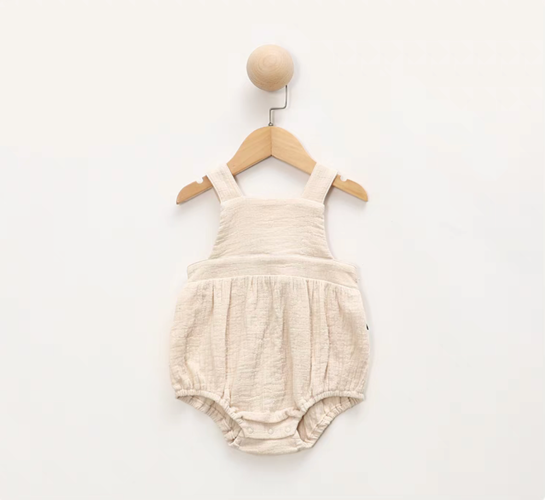 Beige cotton gauze baby romper cross back design soft breathable lightweight summer outfit front view