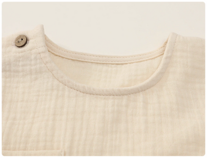 Close up of beige gauze cotton baby set neckline soft breathable fabric texture detail