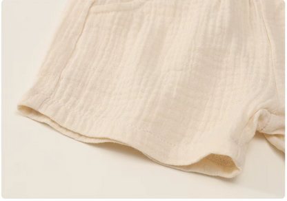 Beige gauze cotton baby shorts hem detail soft breathable fabric texture close up
