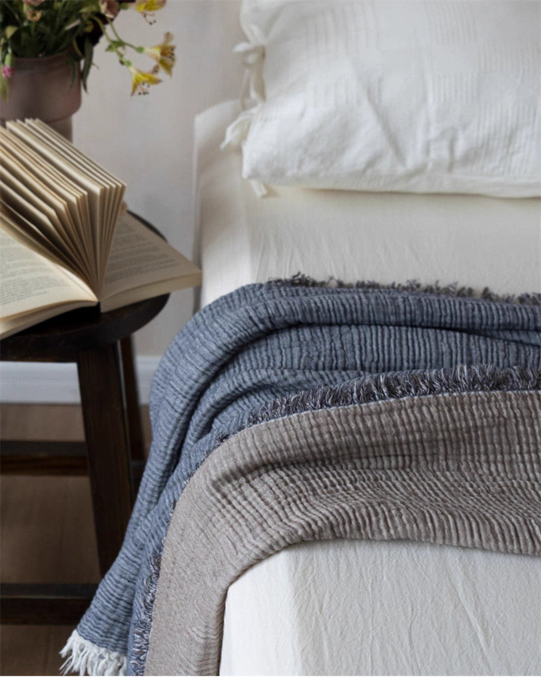 Folded gray khaki dual-color cotton throw blanket on bed showing soft honeycomb gauze texture and fringe edges