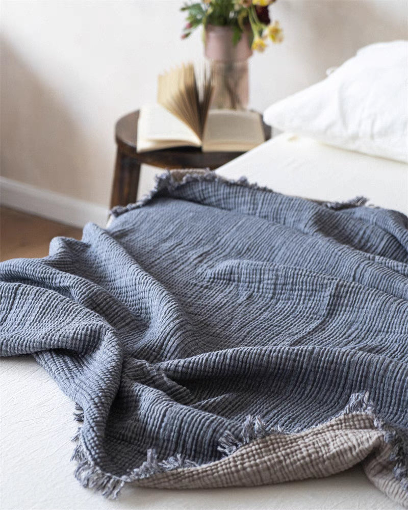 Gray khaki lightweight cotton gauze throw blanket spread across bed highlighting breathable honeycomb woven texture