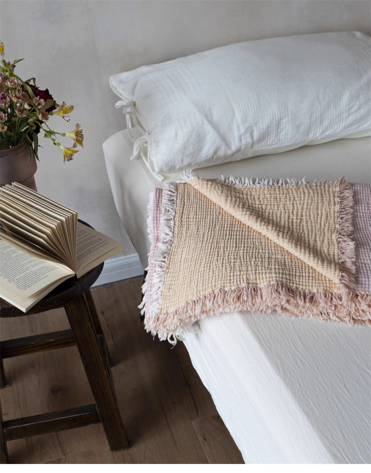 Reversible orange pink cotton gauze throw blanket folded on bed showing two-tone summer blanket design