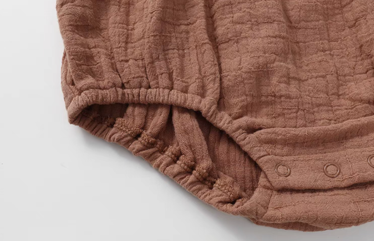 Dusty rose cotton gauze baby romper elastic leg opening detail soft breathable fabric close up