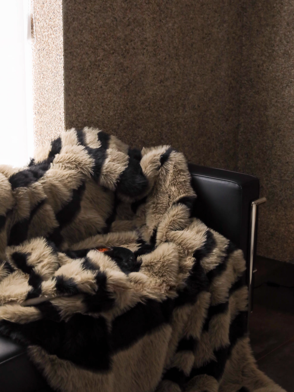 Zebra camel faux fur throw blanket draped over chair highlighting thick fluffy pile and rich texture
