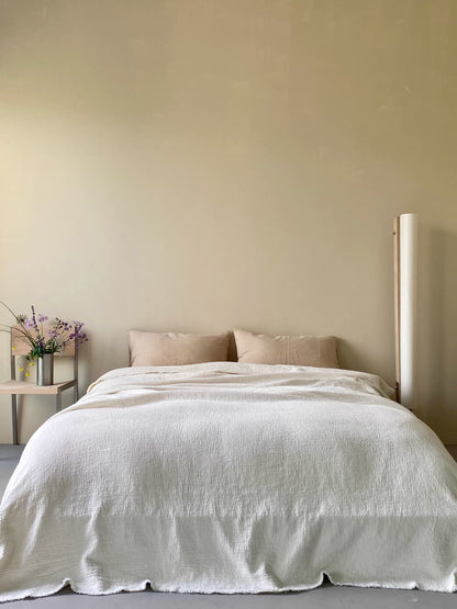 Ivory white French flax linen duvet thin quilt styled on minimalist bedroom bed with soft breathable linen texture