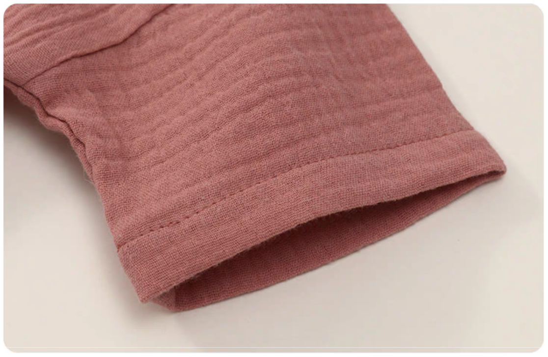 Close up of hot pink gauze cotton baby set sleeve soft breathable fabric texture detail