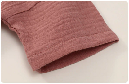 Close up of hot pink gauze cotton baby set sleeve soft breathable fabric texture detail