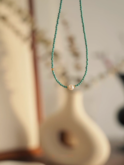 Micro turquoise bead choker with freshwater pearl hanging display in soft natural light lifestyle setting