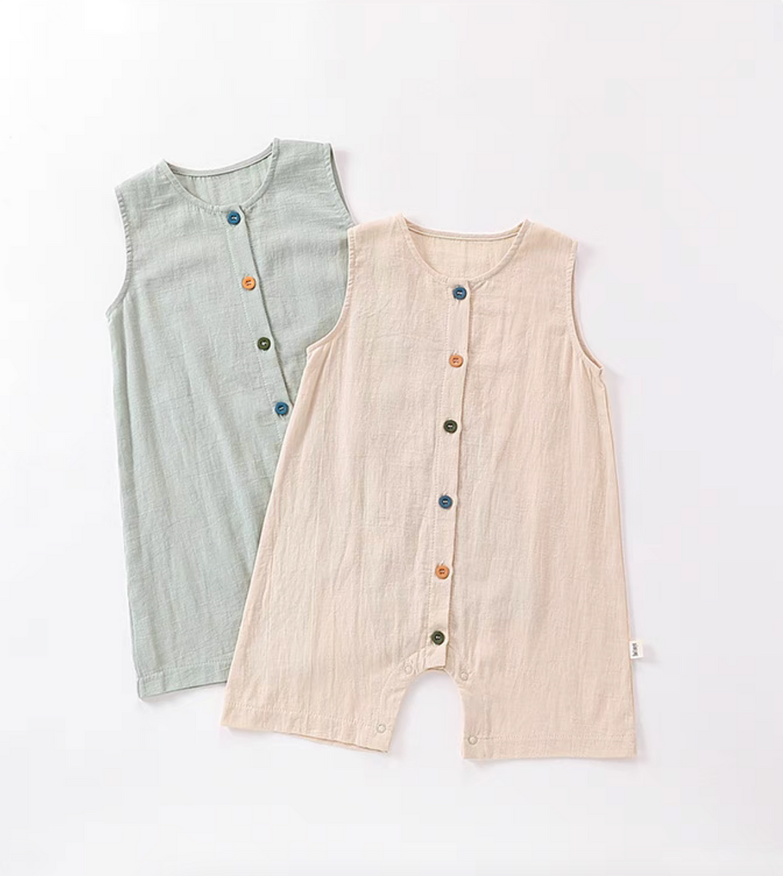 Sage green and peach sleeveless cotton baby rompers with colorful button front soft breathable summer outfit flat lay
